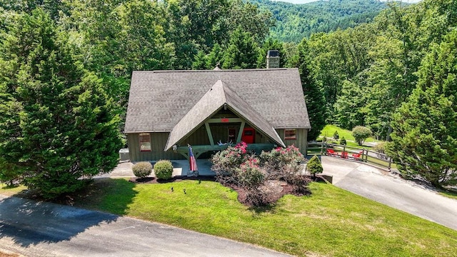 647 Omega Dr, Spring City, TN 37381 - view of front facade with board and batten siding, a view of trees, a front lawn, and roof with shingles