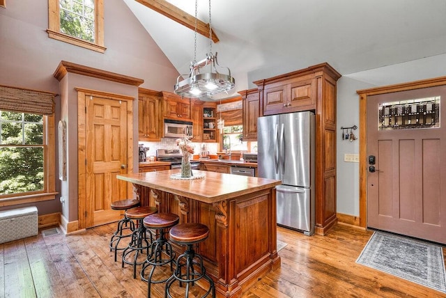 647 Omega Dr, Spring City, TN 37381 - kitchen with stainless steel appliances, high vaulted ceiling, wood counters, a center island, and light wood-style floors