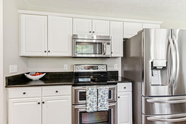 3037 Wilcot Way, Franklin, TN 37069 - kitchen featuring appliances with stainless steel finishes, white cabinetry, a textured ceiling, and dark stone counters
