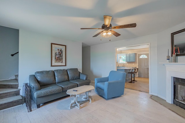 5334 Shelbyville Pike, Christiana, TN 37037 - living area with stairs, ceiling fan, a glass covered fireplace, and light wood-style flooring