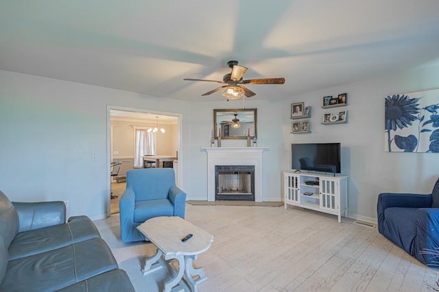 5334 Shelbyville Pike, Christiana, TN 37037 - living area featuring a ceiling fan, light wood-type flooring, and a fireplace with raised hearth