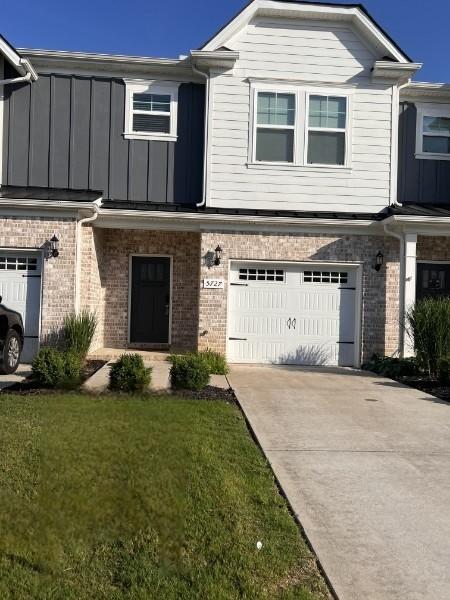 5727 Dockside Dr, Rockvale, TN 37153 - view of front facade featuring an attached garage, driveway, brick siding, a front lawn, and board and batten siding