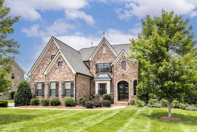 1825 Barnstaple Ln, Brentwood, TN 37027 - view of front of property featuring brick siding, a front yard, a standing seam roof, and roof with shingles