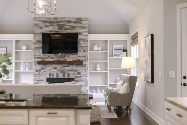 1825 Barnstaple Ln, Brentwood, TN 37027 - living area featuring a stone fireplace, vaulted ceiling, a chandelier, dark wood finished floors, and built in shelves
