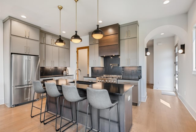 2118 Cliff Dr, Nashville, TN 37218 - kitchen featuring high quality fridge, dark countertops, custom range hood, arched walkways, and gray cabinets