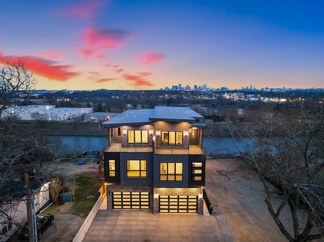 2118 Cliff Dr, Nashville, TN 37218 - back of property at dusk featuring a balcony, an attached garage, and concrete driveway