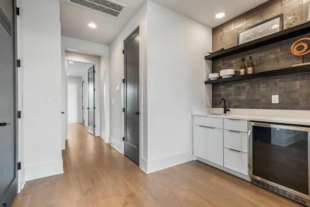 2118 Cliff Dr, Nashville, TN 37218 - indoor wet bar featuring beverage cooler, light wood-type flooring, decorative backsplash, and recessed lighting