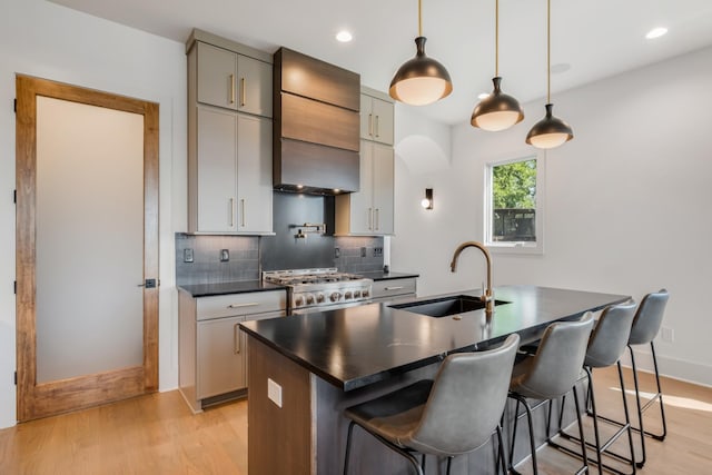 2118 Cliff Dr, Nashville, TN 37218 - kitchen with stove, wall chimney range hood, dark countertops, light wood-style floors, and decorative backsplash