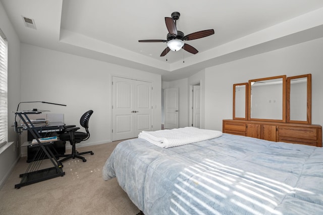 2606 Battleground Dr, Murfreesboro, TN 37129 - bedroom featuring light carpet, a tray ceiling, a closet, and a ceiling fan