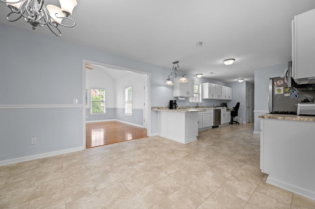 2606 Battleground Dr, Murfreesboro, TN 37129 - kitchen with a chandelier, open floor plan, appliances with stainless steel finishes, light stone counters, and white cabinetry