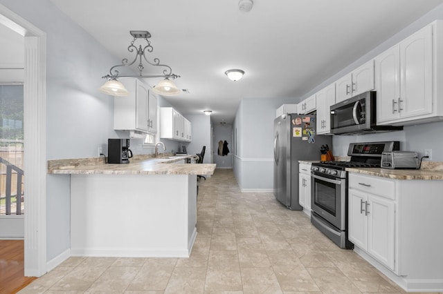 2606 Battleground Dr, Murfreesboro, TN 37129 - kitchen featuring appliances with stainless steel finishes, white cabinets, a peninsula, hanging light fixtures, and light stone counters
