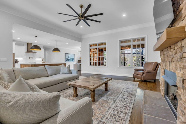 1803 Benziger Ter, Brentwood, TN 37027 - living room with a stone fireplace, ornamental molding, a ceiling fan, recessed lighting, and dark wood-style floors