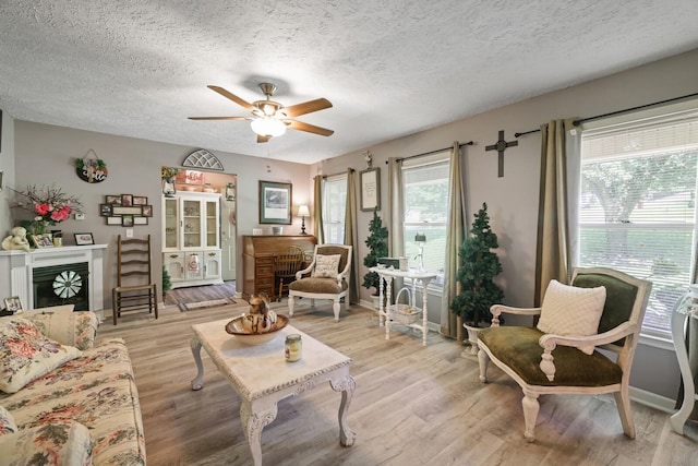 144 Waggoner St, Carthage, TN 37030 - living room with ceiling fan, light wood finished floors, a textured ceiling, and a fireplace