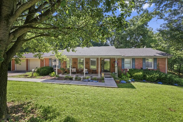 144 Waggoner St, Carthage, TN 37030 - single story home with brick siding, a front lawn, a garage, concrete driveway, and a porch