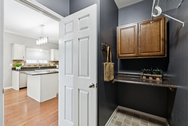 6014 Thrush Ct, Spring Hill, TN 37174 - kitchen with dark countertops, white cabinets, crown molding, stainless steel dishwasher, and pendant lighting
