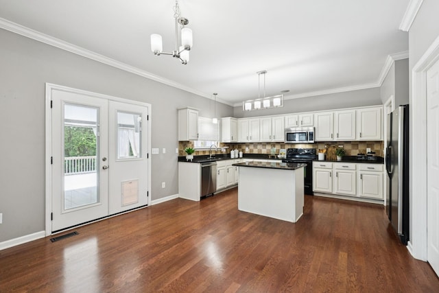 6014 Thrush Ct, Spring Hill, TN 37174 - kitchen featuring appliances with stainless steel finishes, a chandelier, white cabinetry, decorative backsplash, and ornamental molding