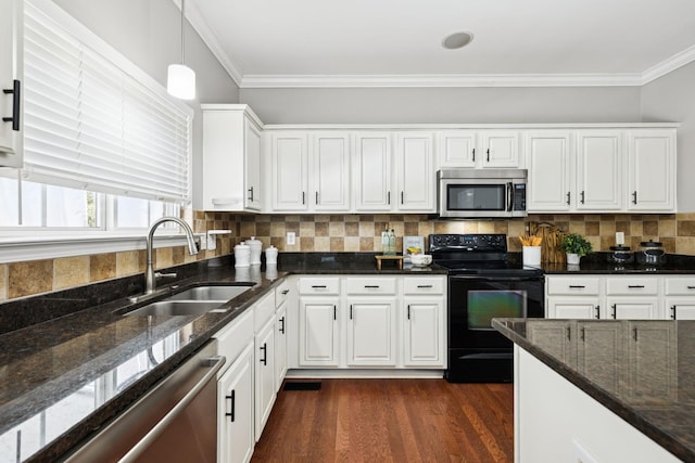 6014 Thrush Ct, Spring Hill, TN 37174 - kitchen with appliances with stainless steel finishes, ornamental molding, dark stone countertops, white cabinets, and dark wood-style flooring