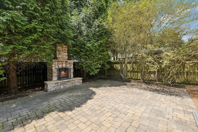 6014 Thrush Ct, Spring Hill, TN 37174 - fenced backyard featuring an outdoor stone fireplace and a patio