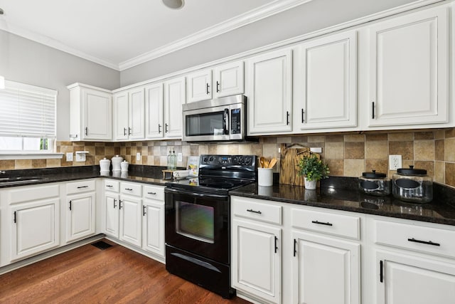 6014 Thrush Ct, Spring Hill, TN 37174 - kitchen featuring stainless steel microwave, black electric range, crown molding, white cabinets, and decorative backsplash
