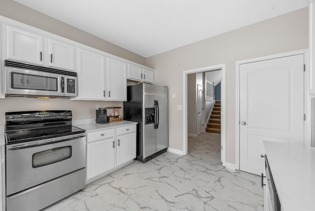 3162 Cross Ridge Dr, Clarksville, TN 37040 - kitchen featuring appliances with stainless steel finishes, light marble finish floors, light countertops, and white cabinets