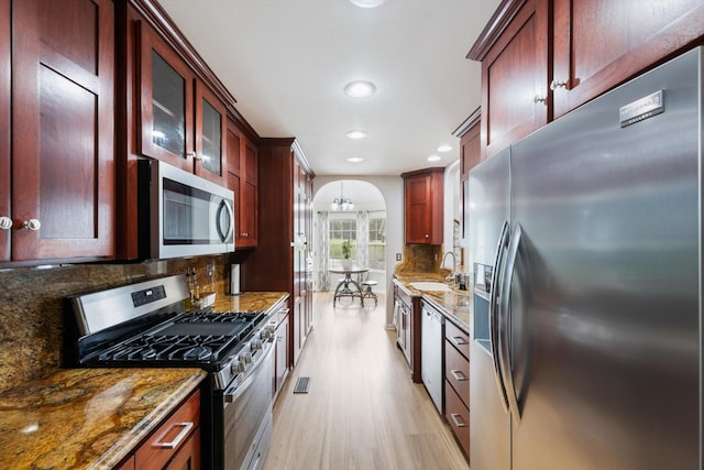 305 Davis Green Ln, Spring Hill, TN 37174 - kitchen with stainless steel appliances, dark brown cabinets, recessed lighting, dark stone counters, and light wood-style floors