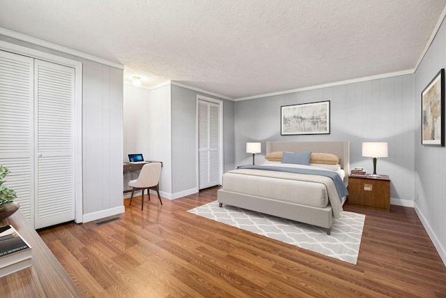 810 Country Club Dr, Clarksville, TN 37043 - bedroom with a desk, ornamental molding, wood finished floors, a textured ceiling, and two closets