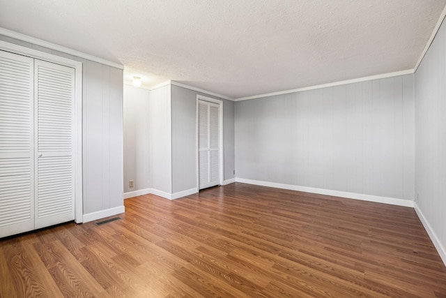 810 Country Club Dr, Clarksville, TN 37043 - unfurnished bedroom featuring wood finished floors, a textured ceiling, crown molding, and two closets
