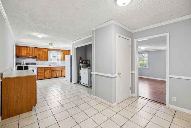 810 Country Club Dr, Clarksville, TN 37043 - kitchen with white appliances, under cabinet range hood, brown cabinetry, light countertops, and light tile patterned flooring