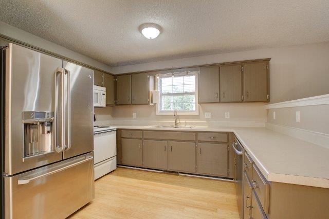 421 Woodale Dr, Clarksville, TN 37042 - kitchen with stainless steel appliances, a textured ceiling, light wood-style flooring, and light countertops