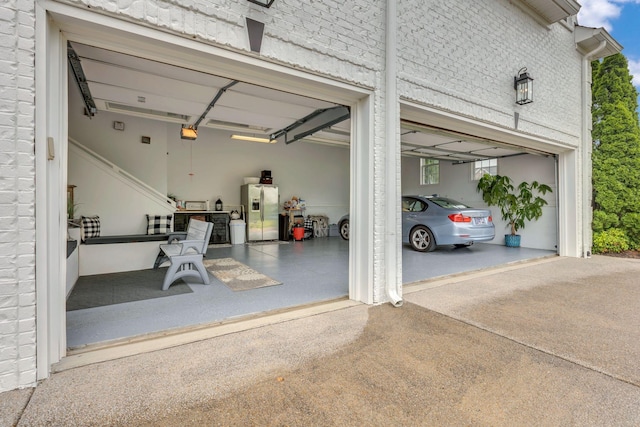2005 Windsong Dr, Spring Hill, TN 37174 - garage with stainless steel fridge, a garage door opener, and concrete driveway