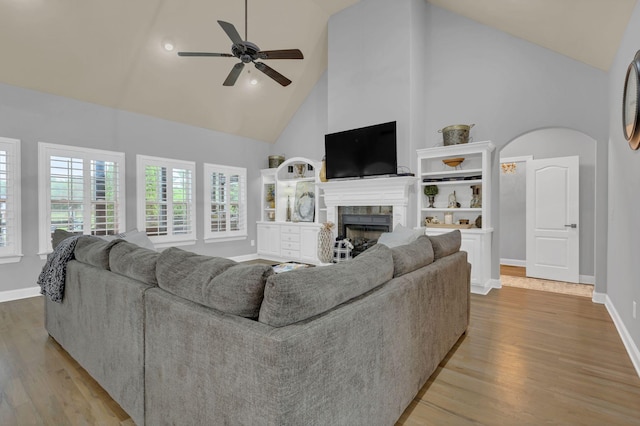2005 Windsong Dr, Spring Hill, TN 37174 - living room featuring high vaulted ceiling, a ceiling fan, wood finished floors, a fireplace, and arched walkways