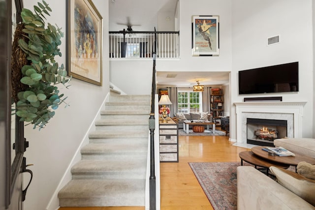 3232 Dark Woods Dr, Franklin, TN 37064 - stairway featuring wood finished floors, ceiling fan, a towering ceiling, and a fireplace