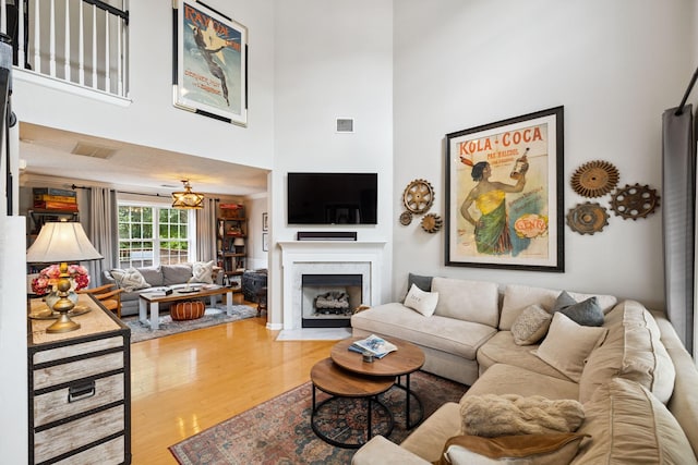 3232 Dark Woods Dr, Franklin, TN 37064 - living area with wood finished floors, a towering ceiling, a fireplace with flush hearth, and a chandelier