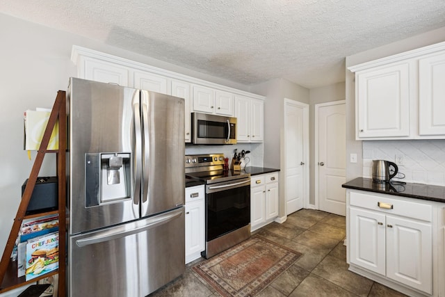 3232 Dark Woods Dr, Franklin, TN 37064 - kitchen featuring stainless steel appliances, dark countertops, white cabinets, and a textured ceiling