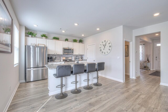 207 Welara St, Murfreesboro, TN 37129 - kitchen with stainless steel appliances, healthy amount of natural light, a center island with sink, light wood finished floors, and recessed lighting