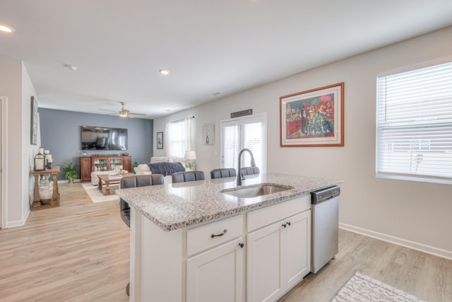 207 Welara St, Murfreesboro, TN 37129 - kitchen with dishwasher, light wood finished floors, an island with sink, white cabinets, and light stone counters