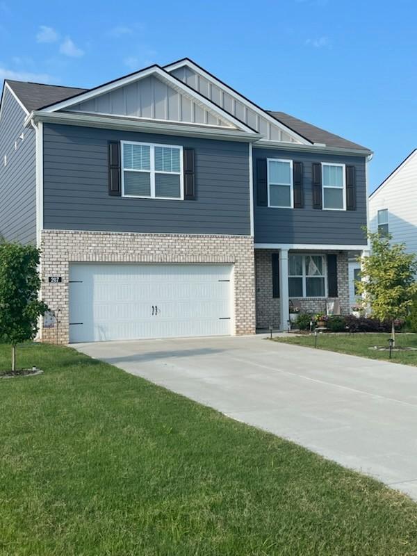 207 Welara St, Murfreesboro, TN 37129 - view of front facade featuring brick siding, a garage, board and batten siding, and a front lawn