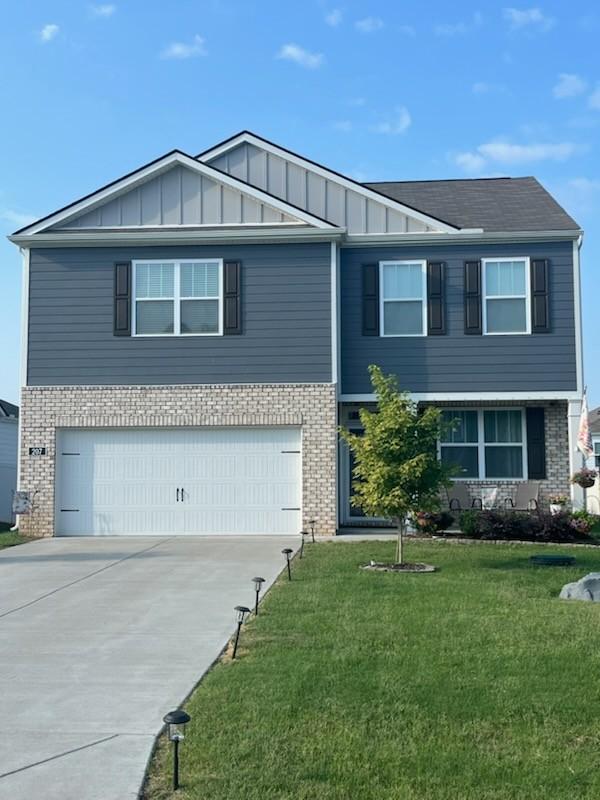 207 Welara St, Murfreesboro, TN 37129 - view of front of home with brick siding, board and batten siding, a garage, and concrete driveway