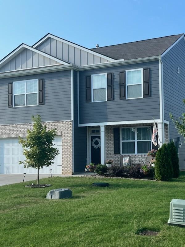 207 Welara St, Murfreesboro, TN 37129 - view of front of home featuring brick siding, a garage, board and batten siding, and a front yard