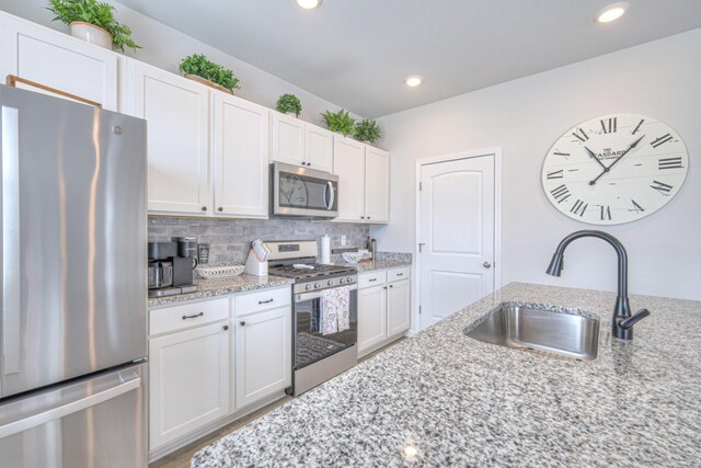 207 Welara St, Murfreesboro, TN 37129 - kitchen with stainless steel appliances, white cabinets, light stone countertops, backsplash, and recessed lighting