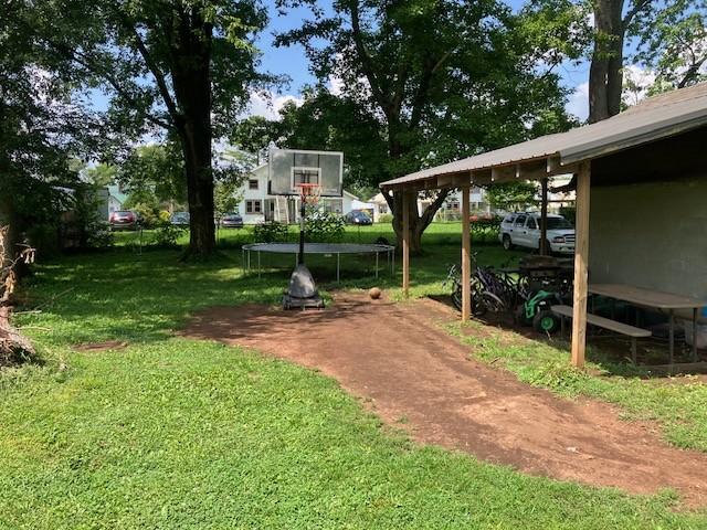 117 Willow St N, Cowan, TN 37318 - view of green lawn featuring a trampoline and a carport