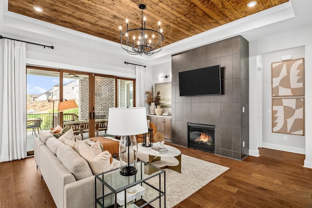 7405 Leelee Dr, Franklin, TN 37064 - living room with wood ceiling, a raised ceiling, dark wood-type flooring, a chandelier, and a tile fireplace