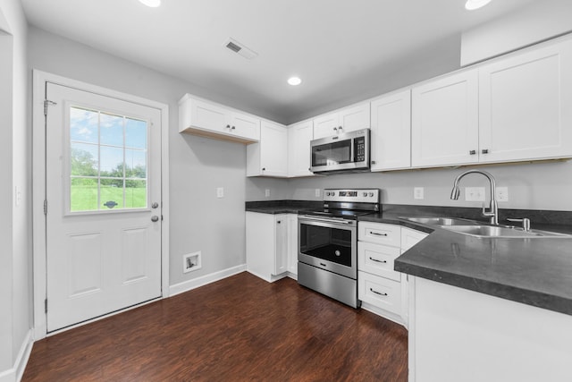 109 Tindell Ln, Columbia, TN 38401 - kitchen with stainless steel appliances, dark wood finished floors, dark countertops, recessed lighting, and white cabinetry