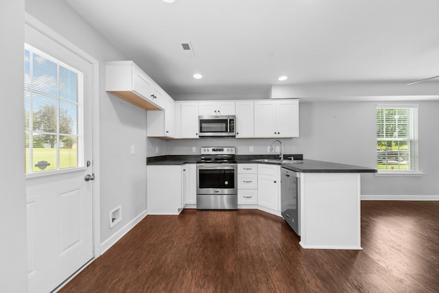 109 Tindell Ln, Columbia, TN 38401 - kitchen with stainless steel appliances, a peninsula, dark wood-type flooring, dark countertops, and recessed lighting