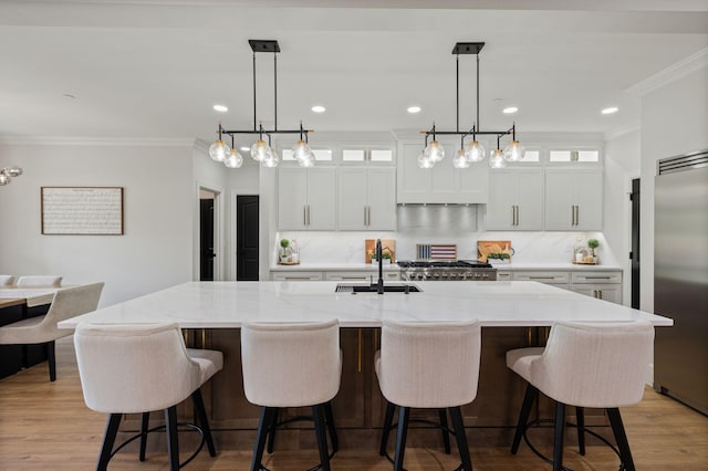 4024 Campania Strada, Spring Hill, TN 37174 - kitchen with stainless steel built in fridge, ornamental molding, a large island with sink, tasteful backsplash, and white cabinets