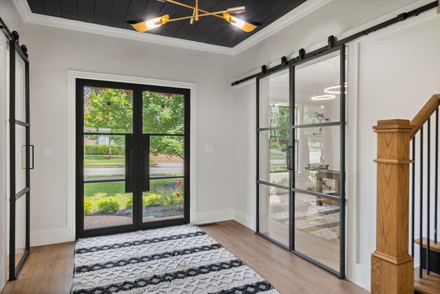 4024 Campania Strada, Spring Hill, TN 37174 - entryway featuring a barn door, ornamental molding, healthy amount of natural light, a chandelier, and wood finished floors