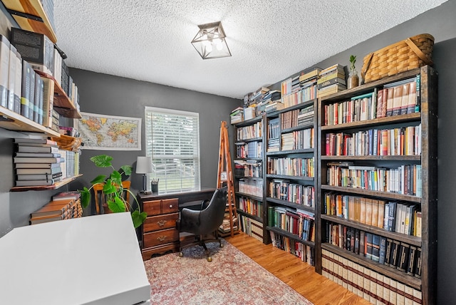178 Miranda Rd, Cadiz, KY 42211 - office area with wood finished floors, a textured ceiling, and wall of books