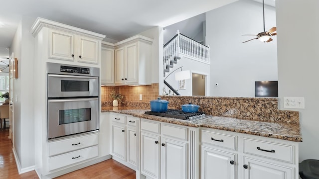 1719 Waterford Rd, Murfreesboro, TN 37129 - kitchen with appliances with stainless steel finishes, decorative backsplash, light stone countertops, light wood-type flooring, and a ceiling fan
