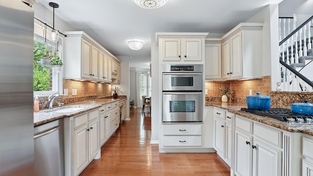 1719 Waterford Rd, Murfreesboro, TN 37129 - kitchen with appliances with stainless steel finishes, decorative backsplash, healthy amount of natural light, and light wood-style floors