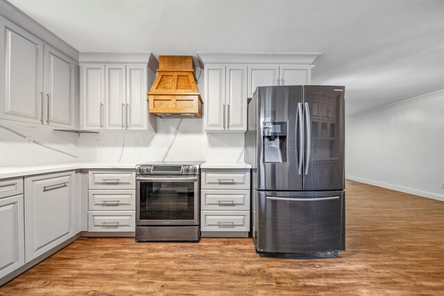 116 Skyview Dr, Columbia, TN 38401 - kitchen with stainless steel appliances, custom range hood, light countertops, light wood finished floors, and ornamental molding